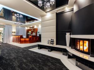 a lobby with a fireplace in the middle of a room at Hotel Skalite Spa & Wellness in Szczyrk