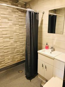 a bathroom with a black shower curtain and a sink at The Players Golf Club in Bristol