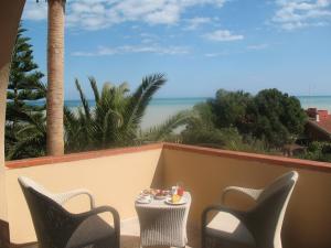 una mesa y sillas en un balcón con vistas al océano en Helios Hotel, en Crotone