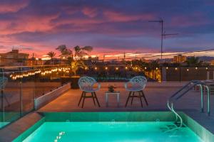 a pool with two chairs and a table on a roof at Santa Pola Apartments in Santa Pola