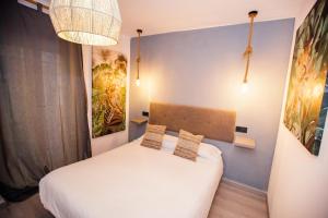 a bedroom with a white bed and a blue wall at Hostal The Monkey Room in Marbella