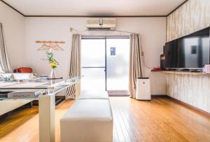 遊泊昭和町YupaStay في أوساكا: غرفة معيشة مع أريكة وطاولة