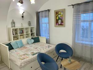 a bedroom with a bed and two blue chairs at Apartmány Kováčska in Košice