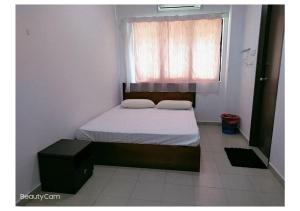 um pequeno quarto com uma cama e uma janela em Pangkor 88 Villa Jia Yuan 邦咯岛家苑海滩度假别墅 em Kampong Pasir Bogak
