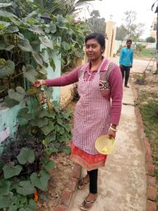 Una donna è in piedi accanto a un giardino di Asian Grand Villa a Bolpur