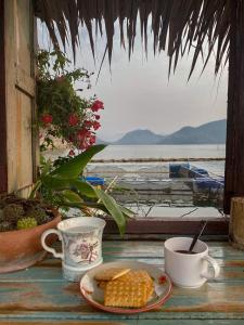 einen Teller Mais auf einem Tisch neben Kaffeetassen in der Unterkunft Sweet Home Floating House in Ban Lum Le