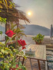 a picnic table on a deck with a view of the ocean at Sweet Home Floating House in Ban Lum Le
