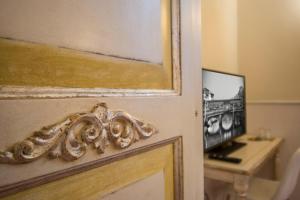 Una puerta a una habitación con escritorio y TV en Relais Tiffany, en Florencia
