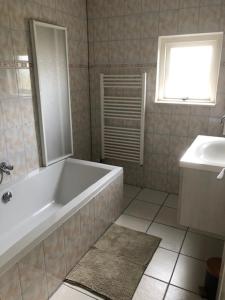 a bathroom with a white tub and a sink at Onder de Walnoot in Ermelo