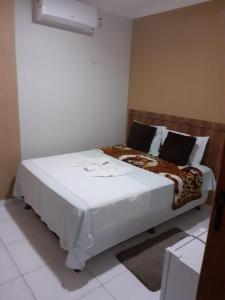 uma cama branca num quarto com em Pousada Santa Maria em Euclides da Cunha