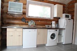 uma cozinha com uma máquina de lavar roupa e uma janela em Pialous:Chalet en rondins avec Espace Détente em La Chapelle-dʼAurec