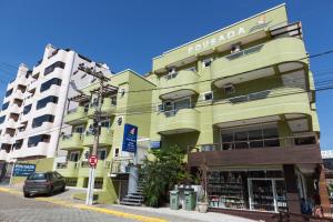 a yellow building on a street with a parking meter at Pousada Brisa do Mar in Bombinhas