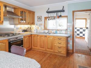 a kitchen with wooden cabinets and a sink at Jasmine Cottage in Rhyl