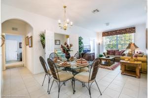 uma sala de jantar e sala de estar com mesa e cadeiras em Three-Bedroom Townhome Kissimmee em Orlando
