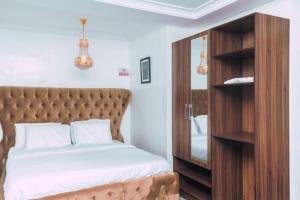 a bedroom with a bed and a wooden cabinet at 247 Luxury Hotel in Lekki