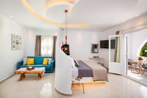 a bedroom with a bed and a blue couch at Abasa Suites in Fira +45 photos