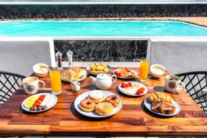 a table with breakfast foods and drinks and a pool at Abasa Suites in Fira