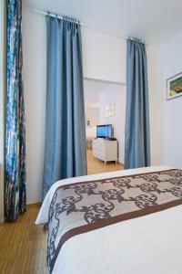 プラハにあるModern Apartment Charvátovaのベッドルーム1室(青いカーテン付きのベッド1台付)