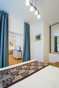 プラハにあるModern Apartment Charvátovaのベッドルーム1室(青いカーテン付きの大型ベッド1台付)
