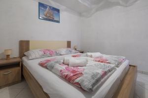 uma cama grande com cobertores cor-de-rosa e brancos em JOVANOVIC em Selce