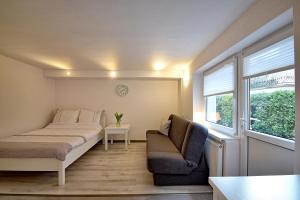 a room with a bed and a couch and a chair at Leokadia przy plaży kwatery prywatne in Mielno
