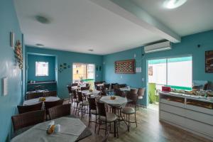 a restaurant with tables and chairs and blue walls at Pousada Brisa do Mar in Bombinhas