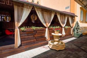 a porch with curtains and a table with a statue at Premier Hotel Shafran in Sumy