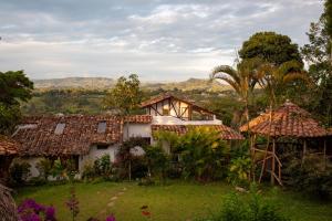 a house in the middle of a field with trees at Hostel Casa de Nelly in San Agustín