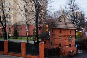 un edificio de ladrillo rojo con techo sobre una valla en KvartiraSvobodna - Apt. Smolenskaya, en Moscú