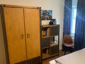 a bedroom with a wooden cabinet and a book shelf at Doppelzimmer in Bensheim