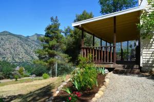 a house with a porch with mountains in the background at The Quail's Nest in Three Rivers
