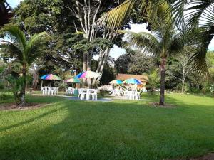 un groupe de tables avec parasols dans un parc dans l'établissement Pousada Toca da Raposa, à Cavalcante