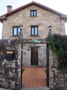 un ingresso a un edificio in pietra con porta di Casa Camino Santiago-Fisterra ad Amés