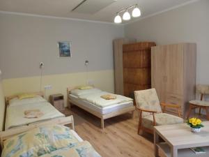 a room with two beds and a table and chairs at Jakus Ház in Nagymaros