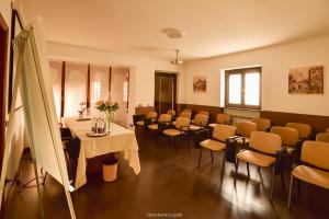 a room with tables and chairs in a room at Hotel Quo Vadis in Udine