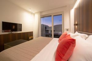 a bedroom with a large bed with red pillows at Le Stanze del Lago Lake View in Como