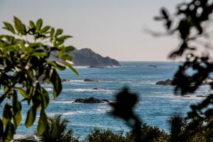 a person is walking on the beach near the ocean at Posada La Sabila in Mazunte