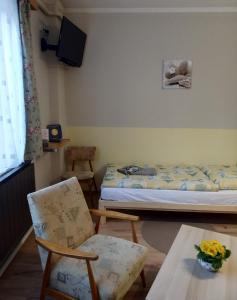 a room with a bed and two chairs and a table at Jakus Ház in Nagymaros