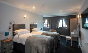 a hotel room with two beds and a desk at The Plough Inn Ripple in Deal