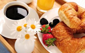 une assiette avec un croissant et une tasse de café et de fraises dans l'établissement At Home Bed and Breakfast, à Lucques