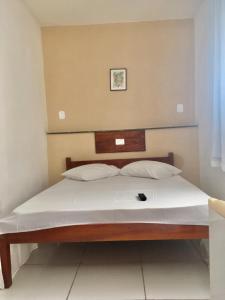 1 dormitorio con 1 cama con sábanas blancas en Hotel Pousada Hamburgo, en Porto Seguro