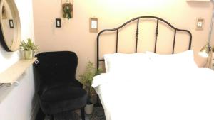 ein Schlafzimmer mit einem Bett und einem Stuhl in der Unterkunft i老宅 in Tainan