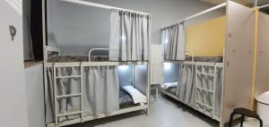 a room with three bunk beds with curtains at Albergue Turistico la Credencial in Santiago de Compostela