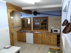 uma cozinha com armários de madeira e um frigorífico branco em Casa Rural La Coja em Villanueva del Condado