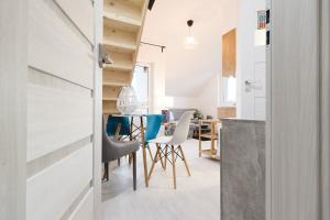 a kitchen and dining room with a table and chairs at Apartamenty Dolce Vita in Ostrowo