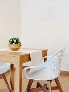 a wooden table and chairs with a potted plant at Arena Gold Euroviajeros apartaments in Pineda de Mar
