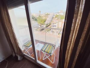 a balcony with a chair and a view of a city at Arena Gold Euroviajeros apartaments in Pineda de Mar