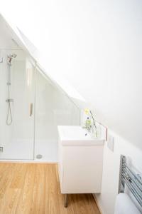 a white bathroom with a sink and a shower at The Barn in Chichester +23 photos