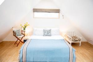 um quarto com uma cama grande e um cobertor azul em The Barn em Chichester