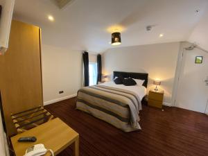 a hotel room with a bed and a table at Spilman Hotel in Carmarthen
